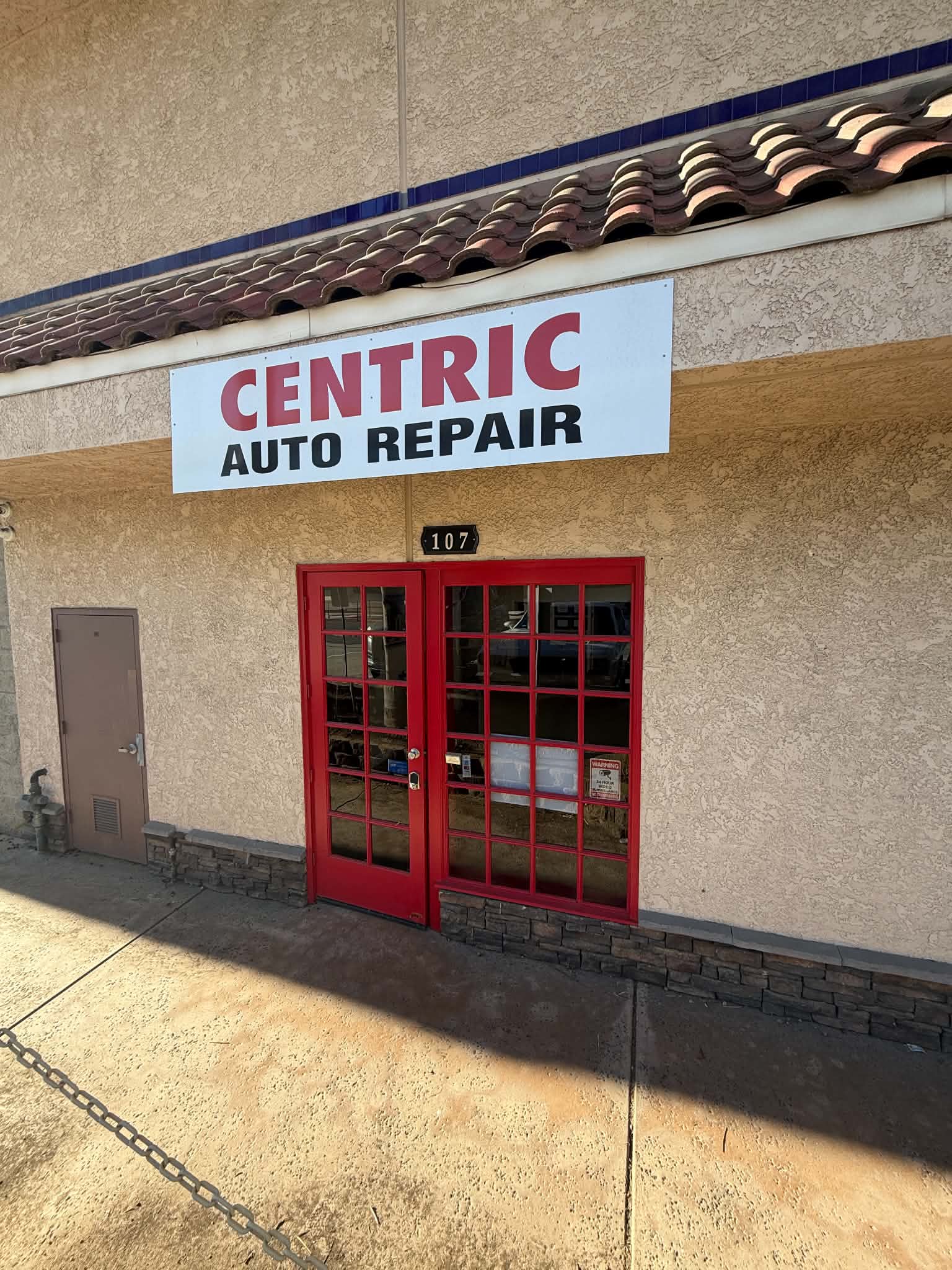 Office entrance: red glass doors below the Centric Auto Repair sign, suite 107